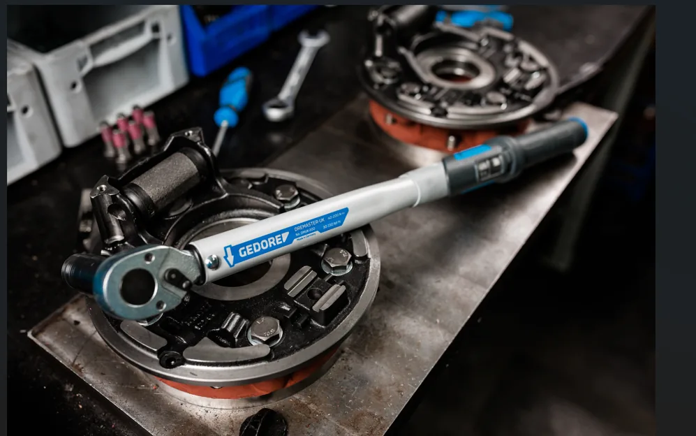 Gedore hand torque wrench tightening a fastener on an engine assembly